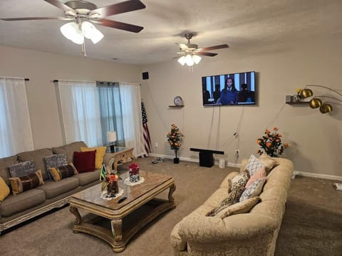 Spacious and inviting living room with comfortable seating, ceiling fans, and a Smart TV. Bright and well-laid-out, it’s a great space for relaxing, watching shows, or spending time together.