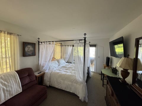 Spacious master bedroom featuring a king-size bed and a sofa bed, offering comfort and flexibility for families. The room includes soft natural light, cozy furnishings, and a calm coastal feel—perfect for restful nights after a day by the water.