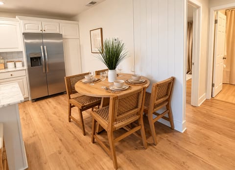 Cozy dining nook for four beside a bright, modern kitchen