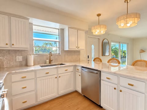 Bright coastal kitchen with peninsula seating and tropical views