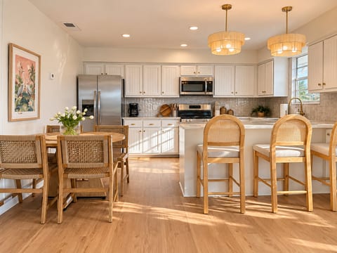 Bright open kitchen with island seating and a warm, stylish dining area