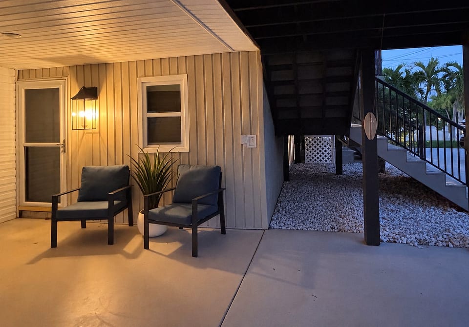 Cozy covered patio entry with lounge seating and warm evening ambiance