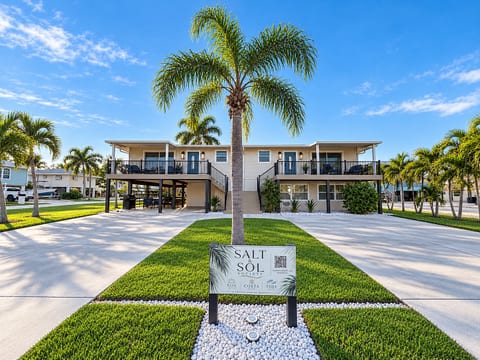 Palm-lined tropical retreat with balconies, parking, and polished curb appeal