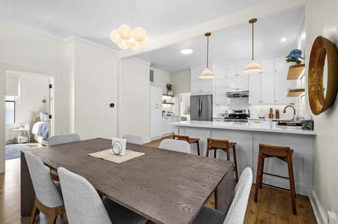 The dining table comfortably seats 6, with the breakfast bar adding extra seating nearby.