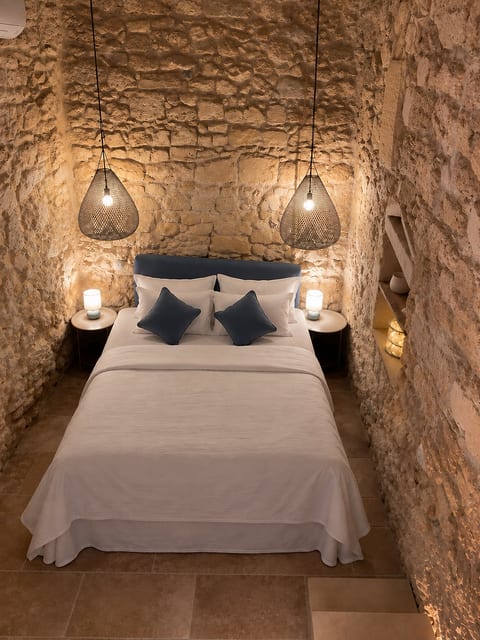 Charming stone-walled bedroom with cozy lighting and boutique-style comfort