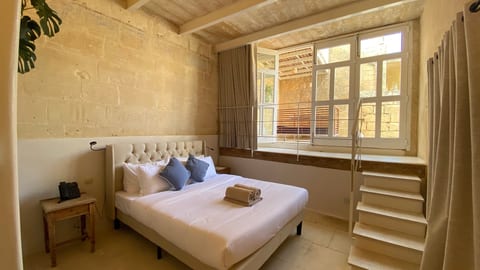 Bright rustic bedroom with a plush bed and charming window nook