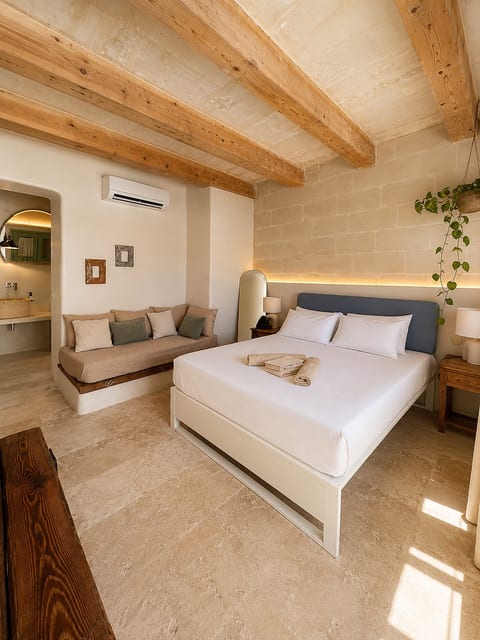 Serene stone bedroom with exposed beams, daybed, and warm modern touches