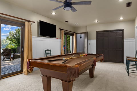 Bright game room with pool table, TV, and patio access