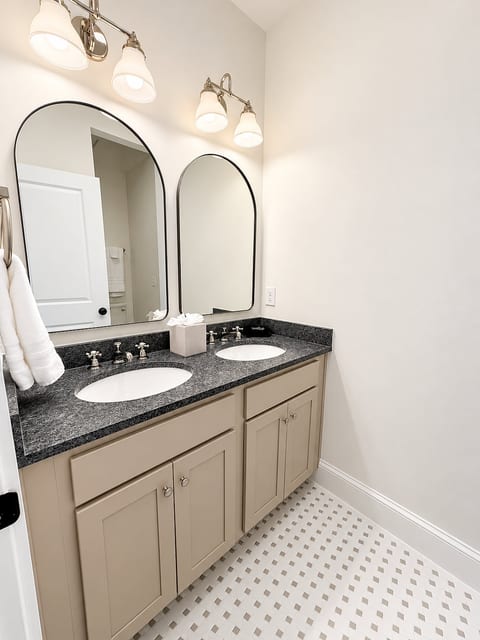 Bright double-vanity bath with elegant mirrors and stylish tile