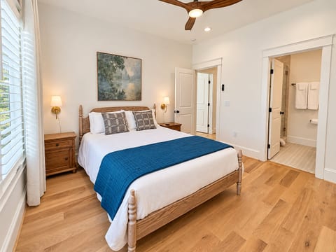 Bright king bedroom with ensuite bath, high ceilings, and stylish wood accents