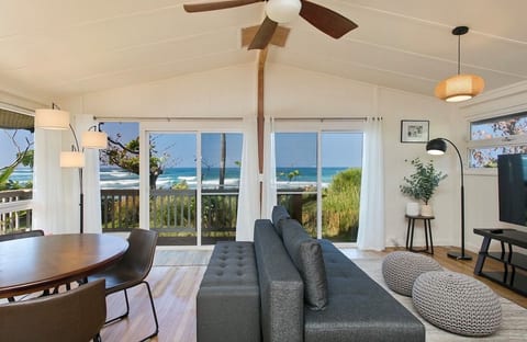 Bright ocean-view living and dining area with sliding doors opening to the lanai.