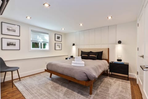 Bedroom on lower levelBedroom on lower level Queen bedroom offering plush sleeping arrangements, fresh towels, and modern aesthetics. Features natural light, room-darkening shades, and bedside reading lamps.