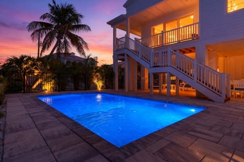 Private heated pool glowing at sunset—perfect for an evening swim after a day at the beach.