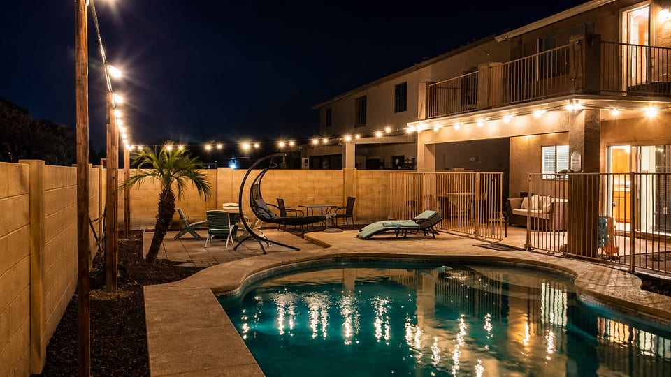 Private lit pool patio with loungers and cozy evening ambiance