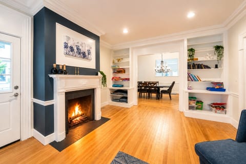 Cozy fireplace lounge with hardwood floors and open dining flow