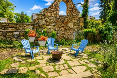 Cozy backyard fire pit patio with Adirondack chairs and rustic stone charm