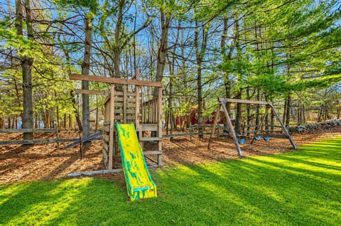 Family-friendly backyard with playset, swings, and peaceful wooded views