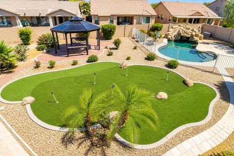 Spacious backyard featuring a lush putting green, gazebo seating area, and a private pool. A perfect mix of relaxation and fun, offering a resort style outdoor experience right at home.