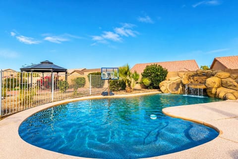 Inviting heated pool with gentle waterfall and comfortable surroundings. The space feels open, peaceful, and perfect for enjoying sunny afternoons or unwinding in a calm outdoor setting.