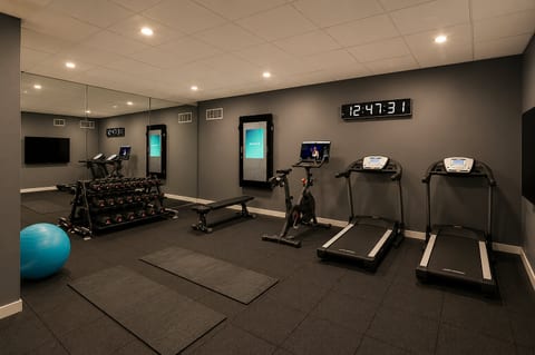 Modern private gym with treadmills, weights, and space for yoga