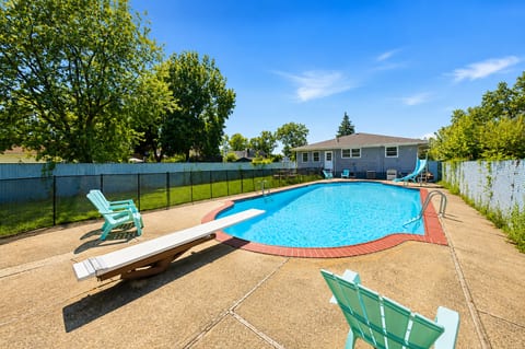 Spacious private pool with diving board, slide, and sunny lounge deck