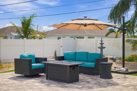 Private patio with fire pit, shaded seating, and tropical backyard vibe