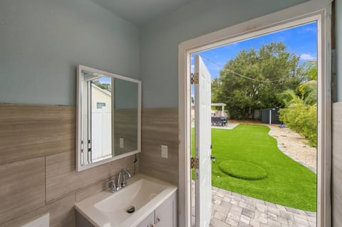 Bathroom with direct access to a lush, private backyard retreat