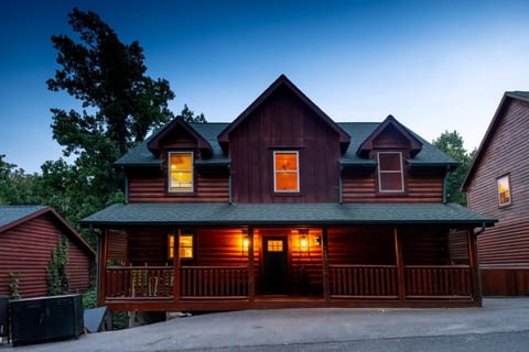 Cozy log cabin with a spacious covered porch and warm evening glow