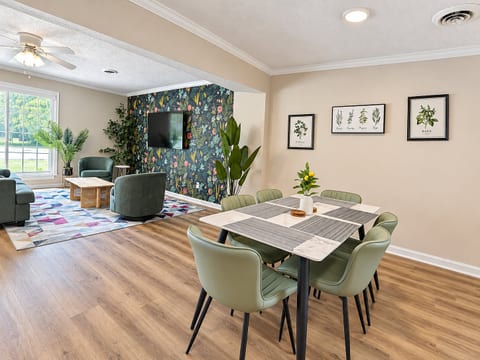 Bright open living + dining space with TV, natural light, and stylish decor