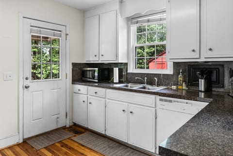 Bright white kitchen with garden views and convenient outdoor access