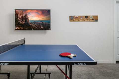 Indoor game room with ping pong table and wall-mounted TV
