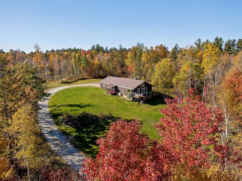 Cabin surrounded by autumn foliage.
