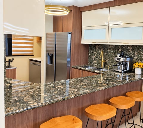 Modern gourmet kitchen with stone bar seating for four