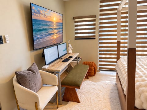 Balance work and relaxation with a bedroom workspace featuring a glass desk and dual monitors. Screen content is digitally staged.