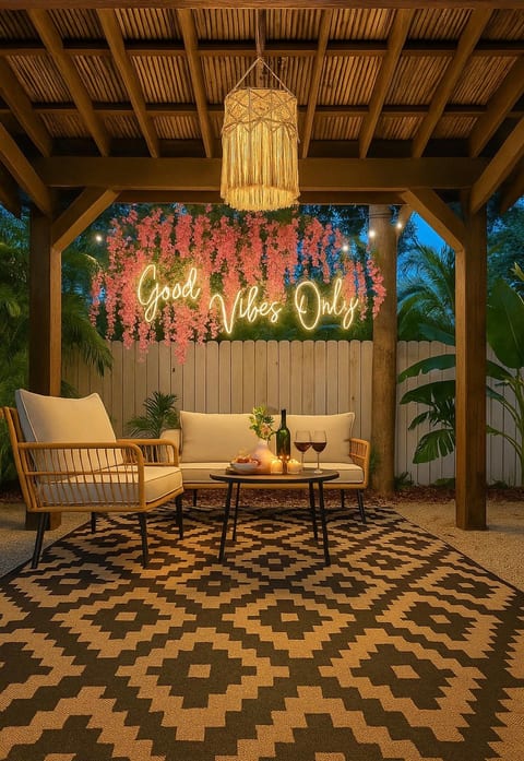 Chic covered patio with cozy seating and a glowing neon photo backdrop