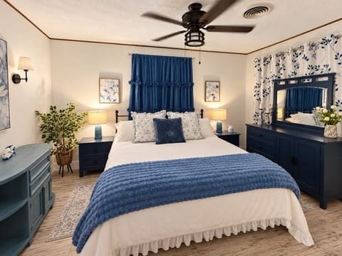 Retreat to our beautifully decorated master bedroom, featuring cozy blue-and-white décor, plush bedding, soft lighting, and charming furnishings. The perfect peaceful escape to relax and recharge after a fun-filled day on Lake Livingston!