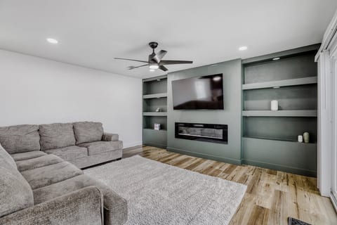 Modern lounge with sectional, fireplace, and large TV for cozy nights in
