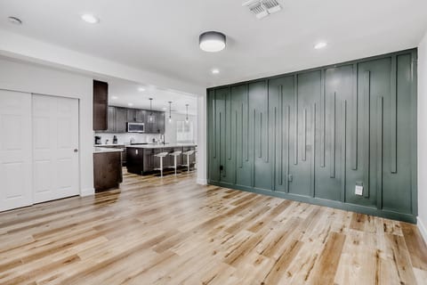 Spacious open-concept room with designer accent wall and modern kitchen