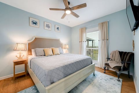 King bedroom with soft lighting and a cozy reading chair
