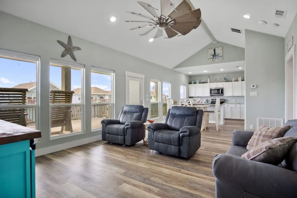 Bright open living room with recliners and vaulted ceilings