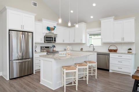 White kitchen with a granite island and stainless appliances