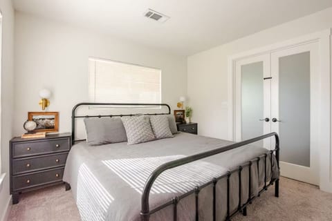 King bedroom with French doors and brass sconces