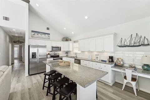 White kitchen with a granite island and bar stools