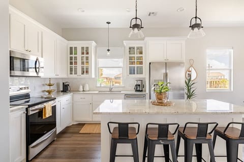 White kitchen with a granite island and bar stools