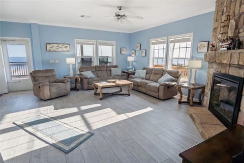 Living room with a stone fireplace and water views