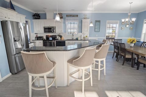 Big kitchen island with bar seating and a dining table for the crew