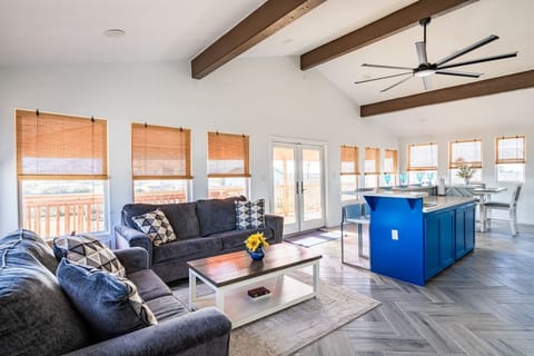 Bright living room with vaulted beams and a wall of windows