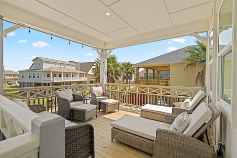 Covered upstairs deck with lounge chairs and a gas fire pit