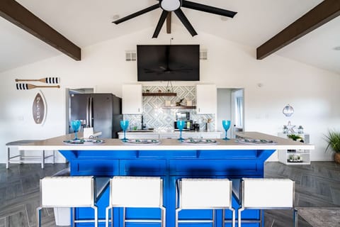 Kitchen with a bold blue island and bar seating