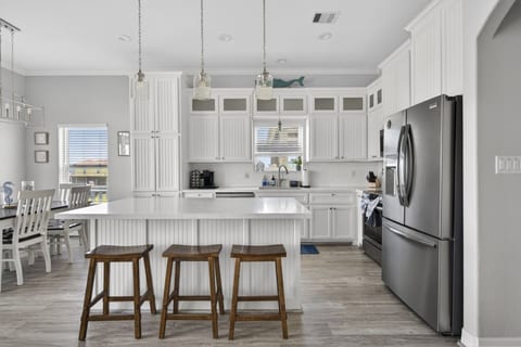 White kitchen with quartz counters and stainless appliances